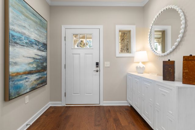 Bright Interior Shot of a Front Entryway with Beige Walls, White Trim, and Wood Floors